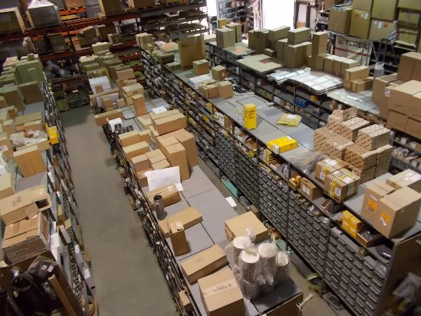 Stacks and shelves full of cardboard boxes and other items inside a warehouse.